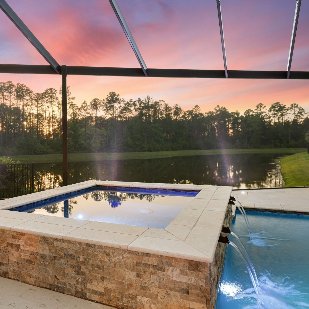 Luxury pool and raised spa with waterfront view inside a screened lanai