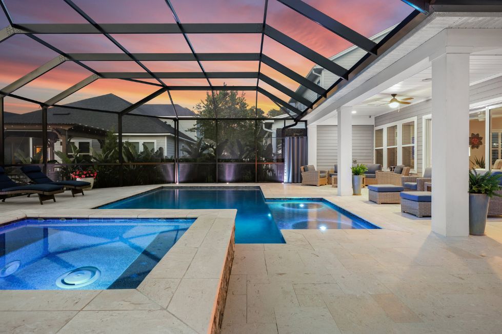 Modern custom swimming pool with attached spa and screened lanai