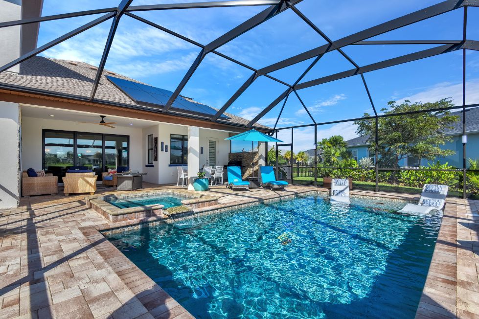 Modern screened pool with sun shelf, spa, and paver deck