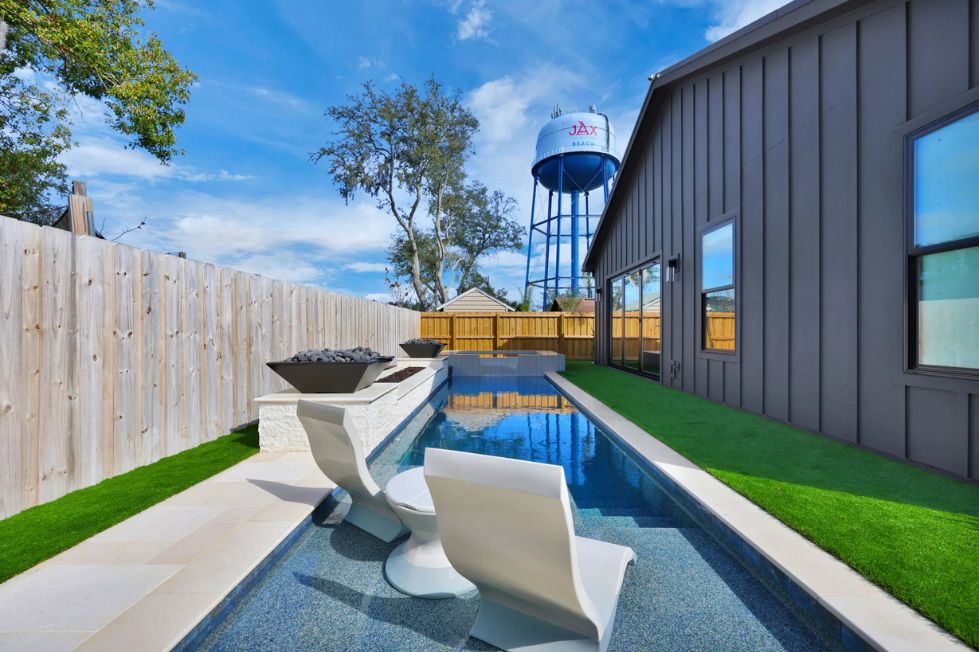 Modern lap pool with tanning ledge and in-water lounge chairs