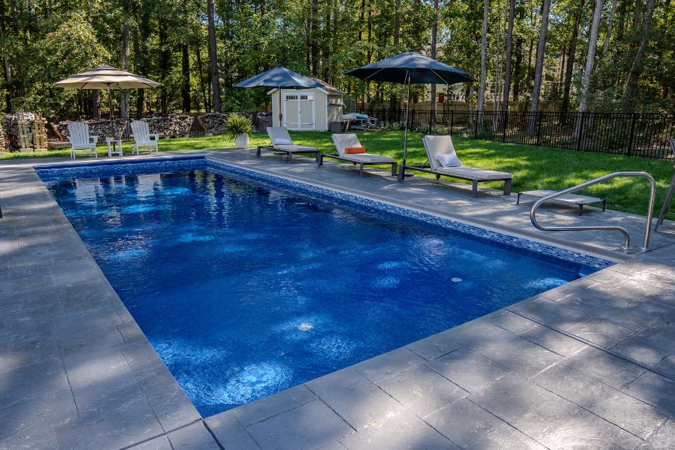 Rectangular backyard pool with lounge chairs