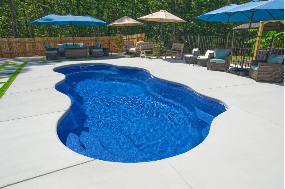 Freeform fiberglass pool with outdoor seating area