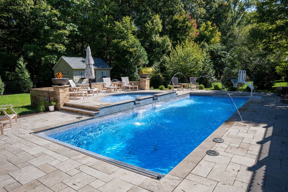 Luxury rectangular backyard pool with raised spa and deck jets