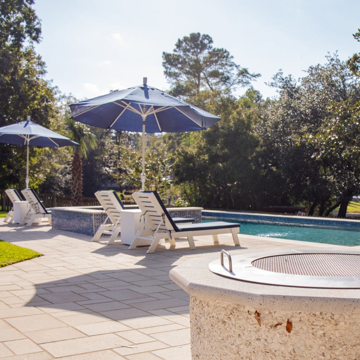 Tanning ledge with in-pool loungers and umbrella shade