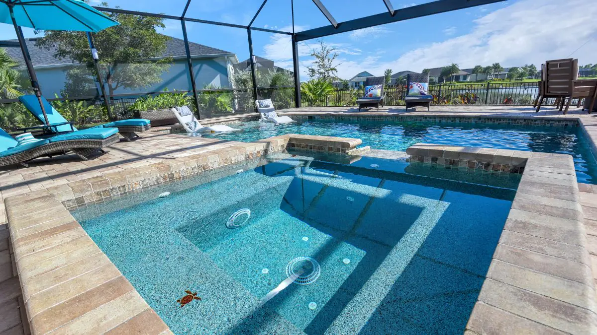 Custom gunite pool with raised spa, tanning ledge, and screened enclosure