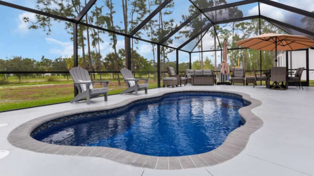 Freeform fiberglass pool with a screened enclosure