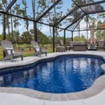 Freeform fiberglass pool with a screened enclosure