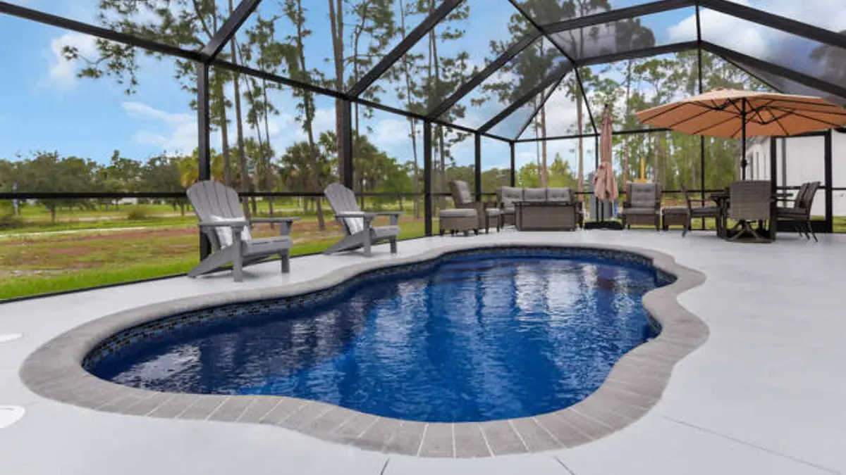 Freeform fiberglass pool with a screened enclosure