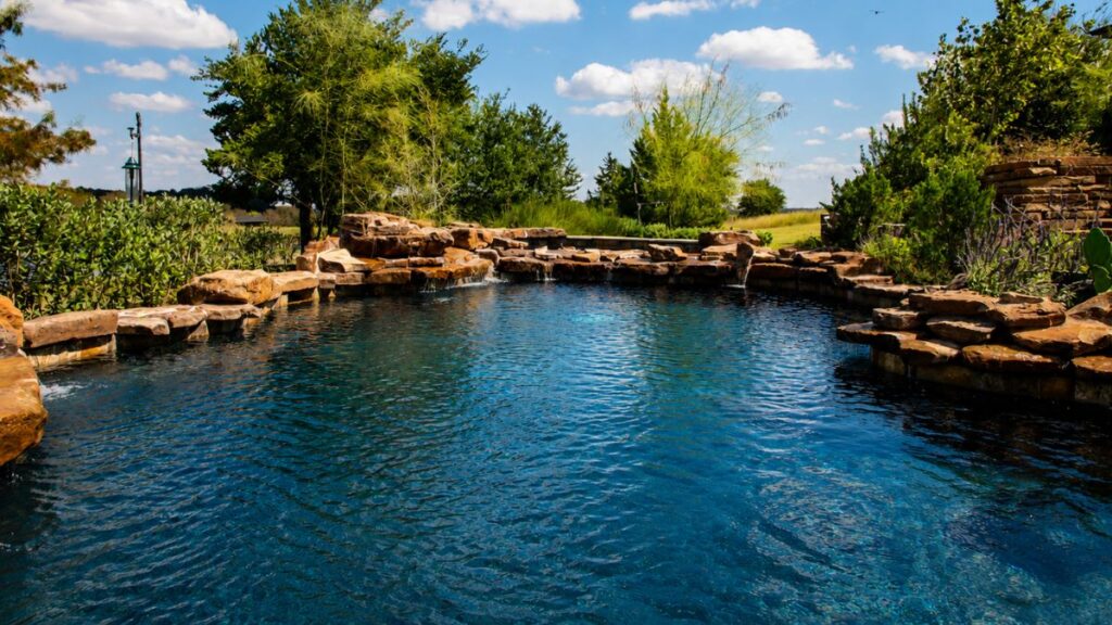 Natural rock swimming pool with a lagoon-style design and cascading stone waterfalls