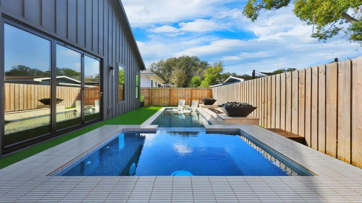 Modern backyard with raised spa, swimming pool, artificial turf, and wood deck