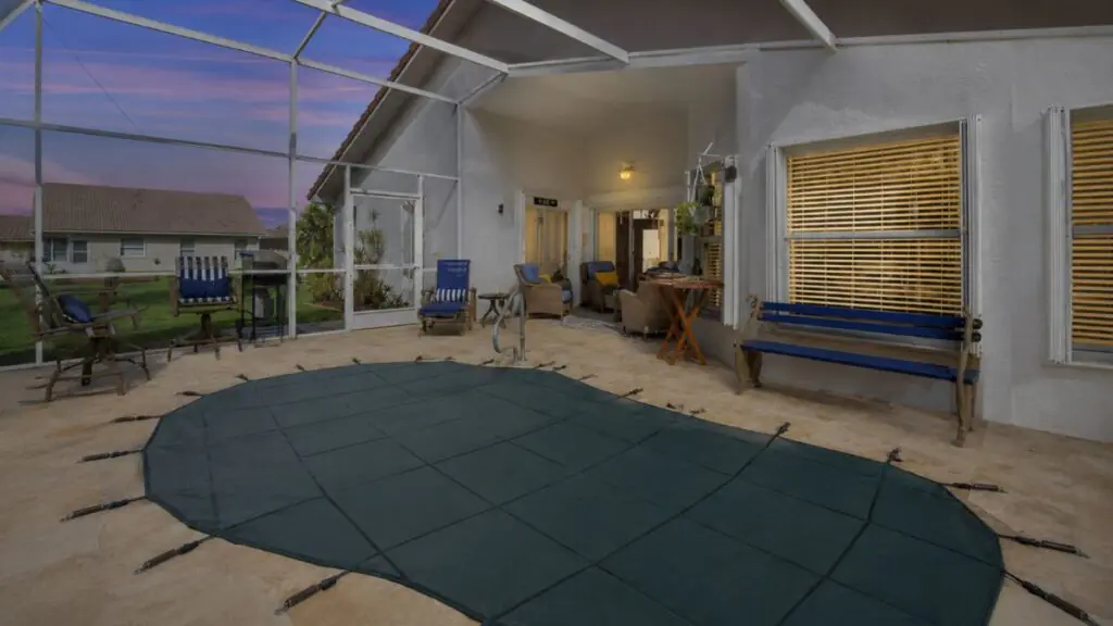 Screened pool patio with outdoor seating and covered pool area at sunset